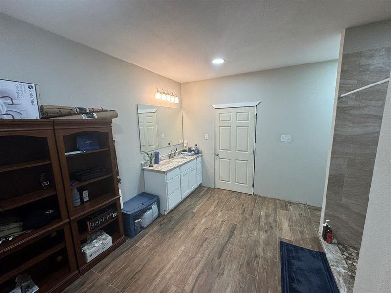 Full bathroom with dark wood finished floors, vanity, tiled shower, and recessed lighting Full bathroom with dark wood finished floors, vanity, tiled shower, and recessed lighting