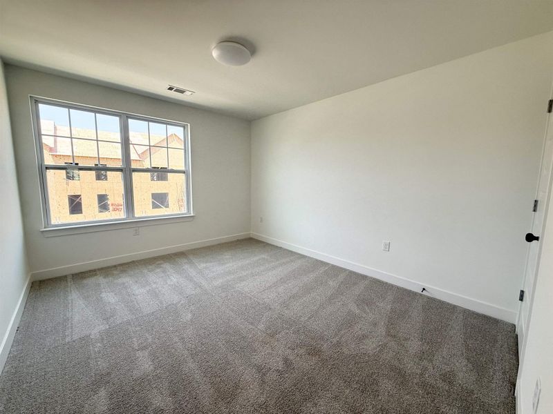 Unfurnished room featuring light carpet and baseboards