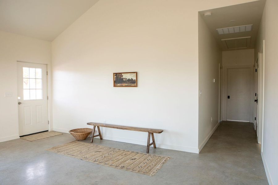 Entryway featuring finished concrete floors and vaulted ceiling Entryway featuring finished concrete floors and vaulted ceiling