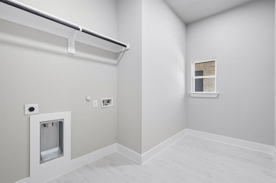 Laundry room featuring gas dryer hookup, light wood finished floors, electric dryer hookup, and washer hookup