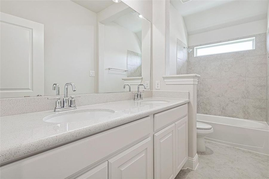 Full bathroom featuring tile patterned floors, vanity, toilet, and tiled shower / bath combo