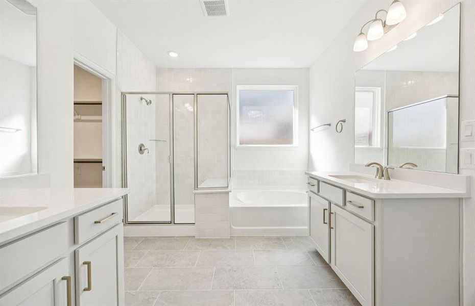 Owner's bath with separate sinks and cabinetry