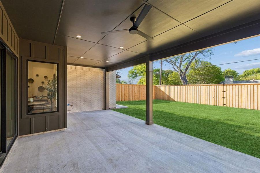 Fenced backyard with a ceiling fan and a patio