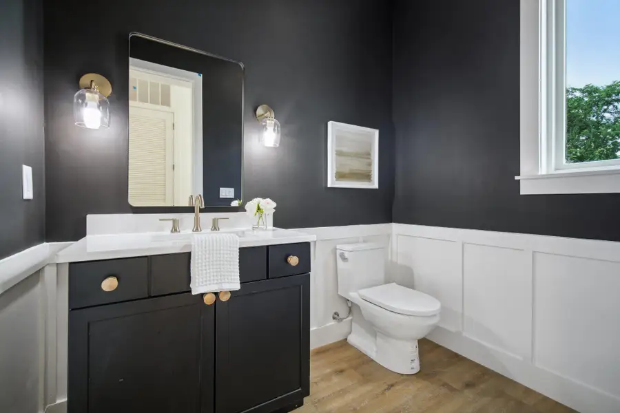 Bathroom with light wood-style flooring, vanity, and a wainscoted wall