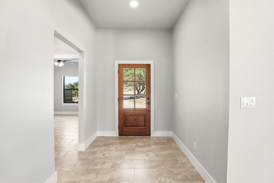 A welcoming entry features a stylish wooden door with glass panels and durable tile flooring. A welcoming entry features a stylish wooden door with glass panels and durable tile flooring.