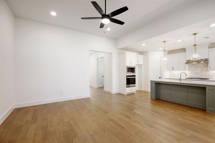 Open-concept living space featuring wood-finish flooring, recessed lighting, and a modern ceiling fan