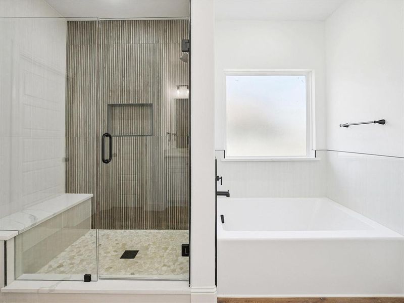 Bathroom featuring a garden tub and a shower stall