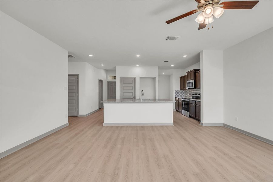 Unfurnished living room with recessed lighting, a ceiling fan, and light wood finished floors