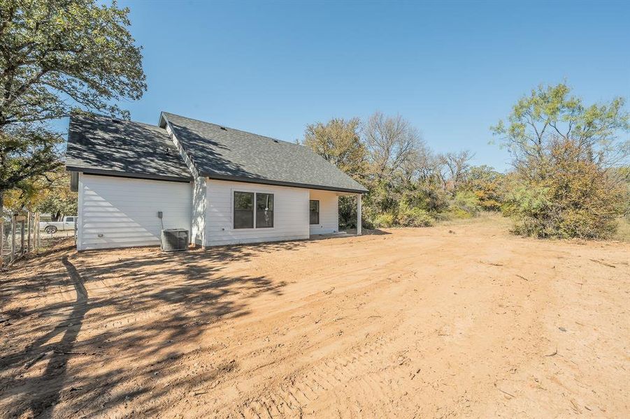 Back of house with a patio and a shingled roof