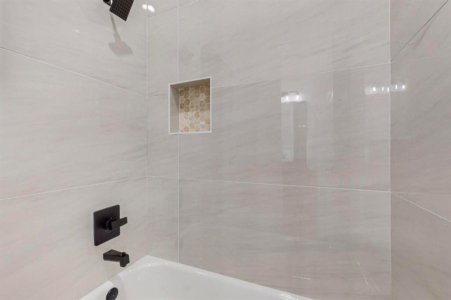 Room details featuring tiled shower / bath combo