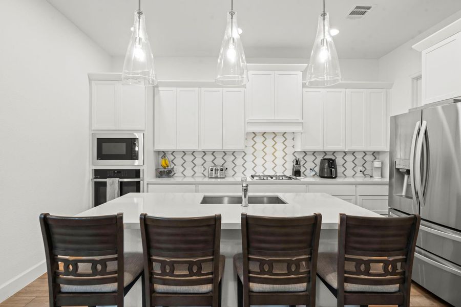 At the center of it all, a grand island serves as the true heart of the kitchen—offering abundant storage, casual breakfast seating, and striking pendant lighting. Whether prepping gourmet meals or hosting lavish gatherings, this space delivers both beauty and practicality in perfect harmony