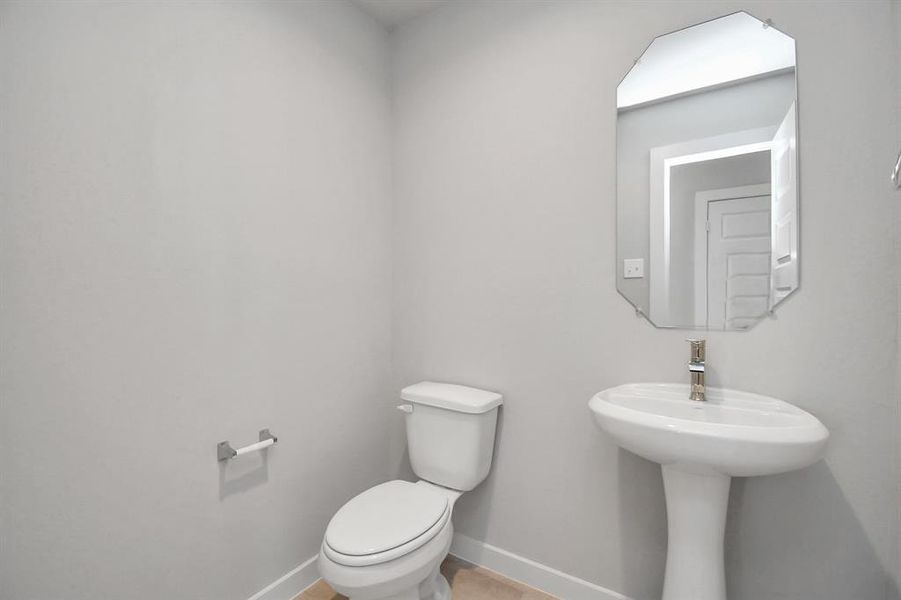 Immerse yourself in modern elegance within this delightful half bathroom. Sample photo of completed home with similar floor plan. As-built interior colors and selections may vary.