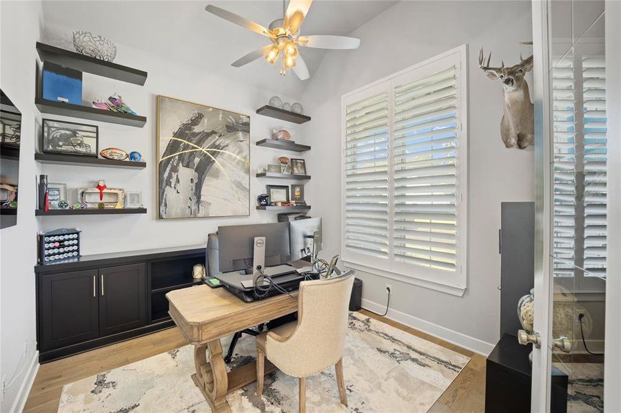 Home office with lofted ceiling, light wood-type flooring, and ceiling fan