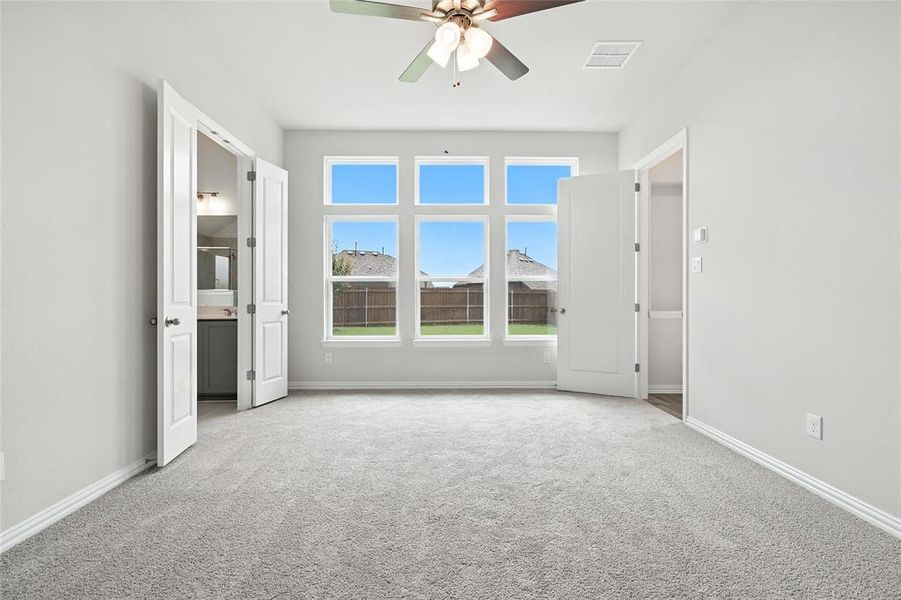 Unfurnished room with ceiling fan and light colored carpet