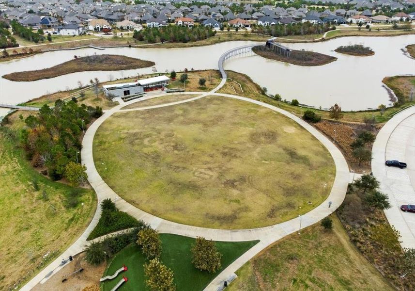 Expansive central green space surrounded by walking trails and lakes, creating the perfect setting for outdoor recreation and community events.