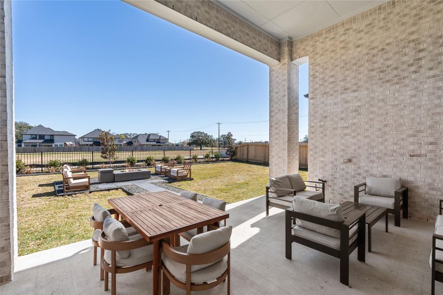 Outdoor covered patio with seating area overlooking a well-maintained lawn, perfect for relaxation. Outdoor covered patio with seating area overlooking a well-maintained lawn, perfect for relaxation.
