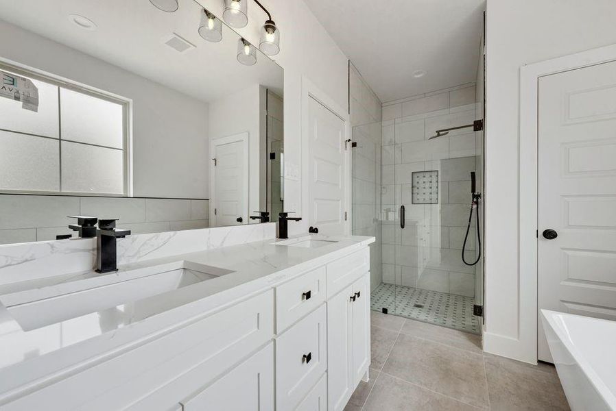 Full bath with double vanity, a shower stall, and a soaking tub