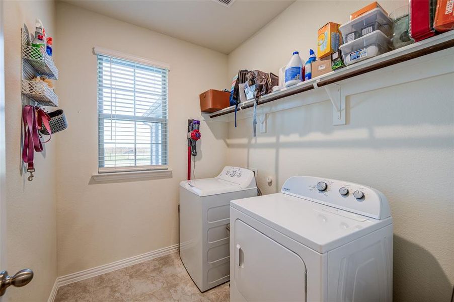 Laundry area with washer and clothes dryer and baseboards