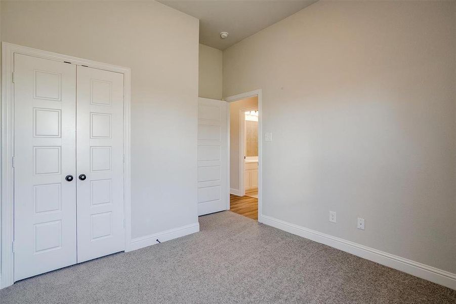 Unfurnished bedroom featuring light colored carpet and a closet