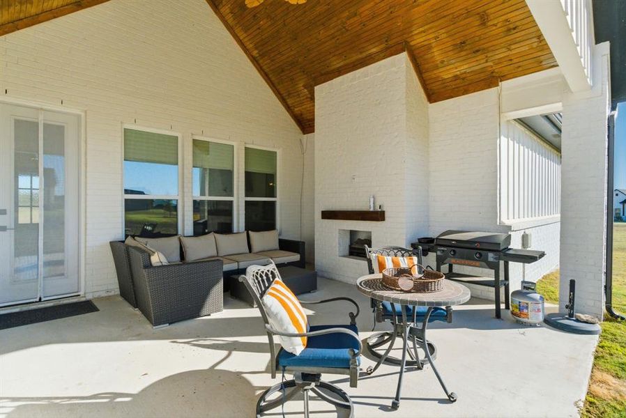 View of patio / terrace featuring an outdoor living space with a fireplace and a grill