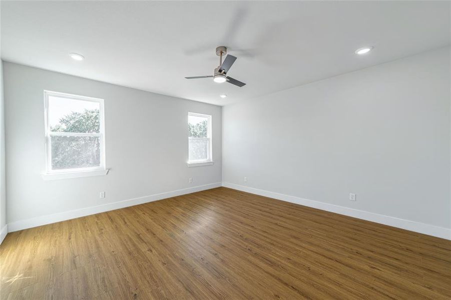Empty room featuring wood finished floors and recessed lighting Empty room featuring wood finished floors and recessed lighting