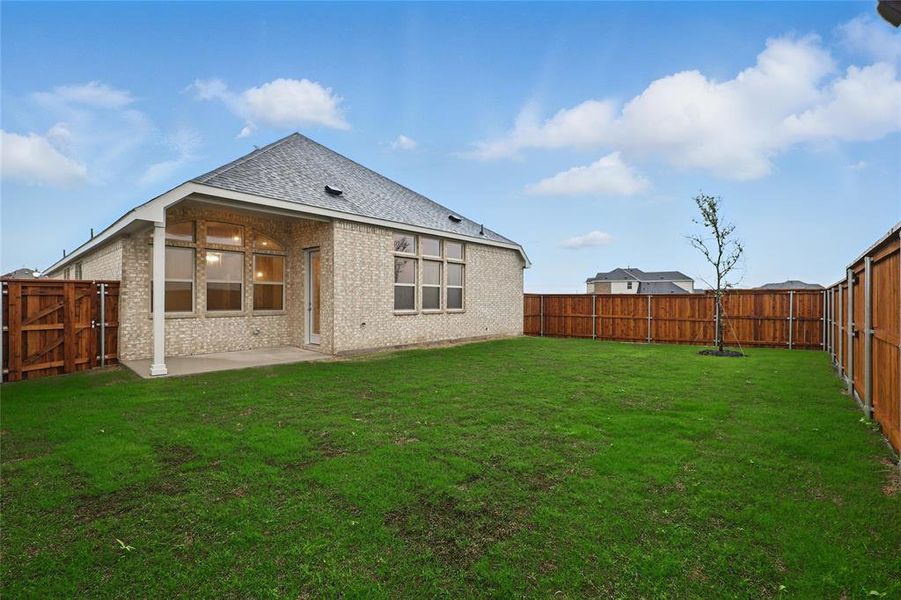 Rear view of house featuring brick siding, a fenced backyard, and a patio Rear view of house featuring brick siding, a fenced backyard, and a patio
