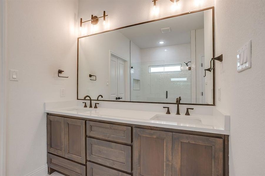 Full bathroom with double vanity and a shower stall