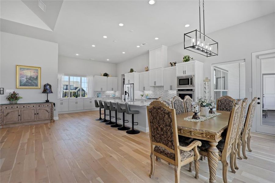Dining space with light wood finished floors, recessed lighting, and a chandelier Dining space with light wood finished floors, recessed lighting, and a chandelier