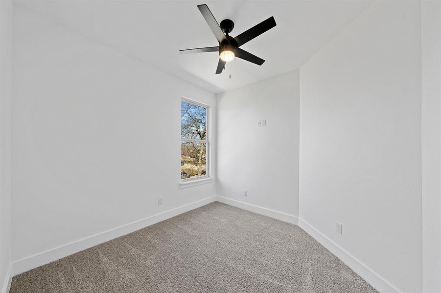 Unfurnished room with a ceiling fan, baseboards, and carpet flooring