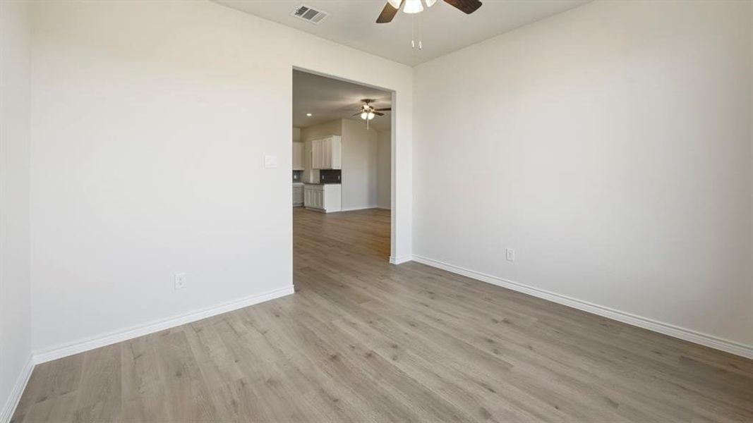 Empty room with light wood finished floors and ceiling fan