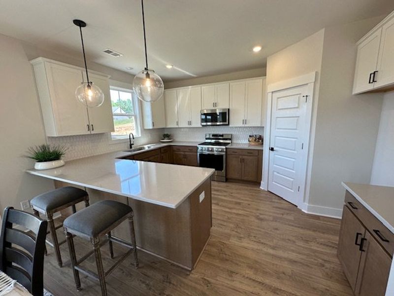 This modern kitchen features warm wood flooring an