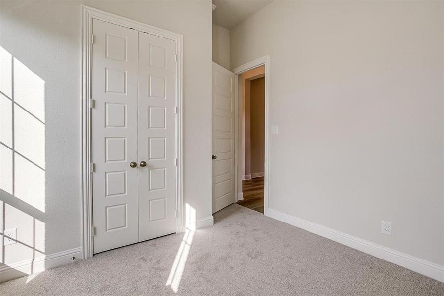 Unfurnished bedroom featuring light colored carpet and a closet