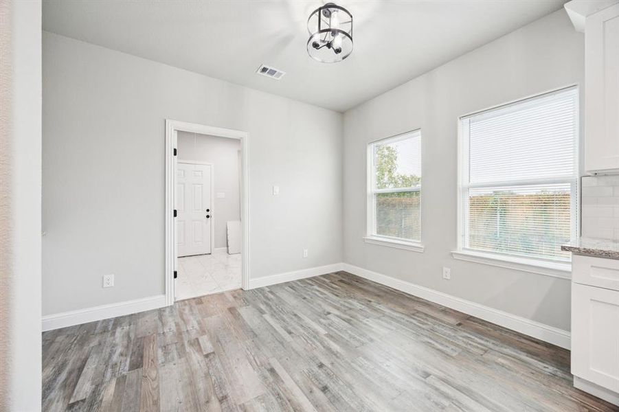 Breakfast area with light wood-style floors and baseboards (out of photo has a buffet cabinet) Breakfast area with light wood-style floors and baseboards (out of photo has a buffet cabinet)