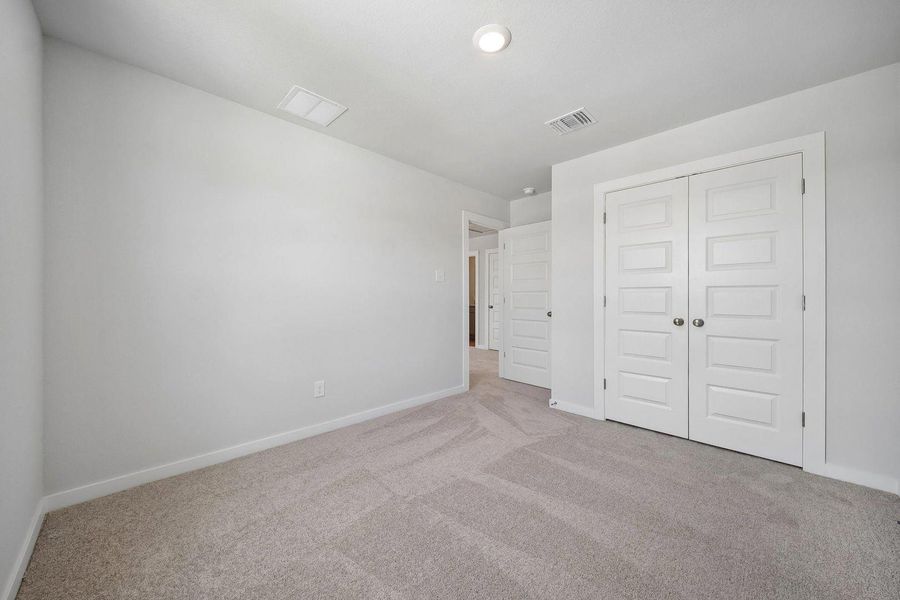 A spacious and neutral secondary bedroom with plush carpeting, perfect for peaceful repose. A spacious and neutral secondary bedroom with plush carpeting, perfect for peaceful repose.