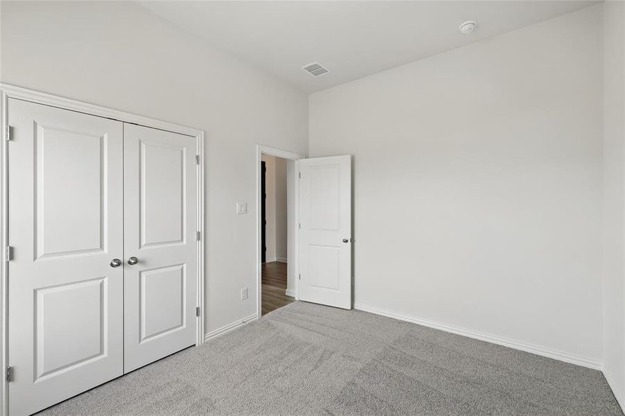 Unfurnished bedroom with carpet and a closet