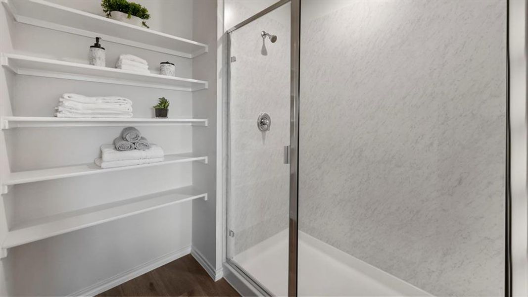 Bathroom with a stall shower, dark wood finished floors, and a closet Bathroom with a stall shower, dark wood finished floors, and a closet