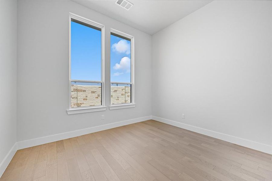 Empty room featuring light wood-style floors and baseboards Empty room featuring light wood-style floors and baseboards