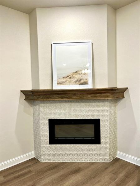 Detailed view of wood finished floors, a tiled fireplace, and baseboards Detailed view of wood finished floors, a tiled fireplace, and baseboards