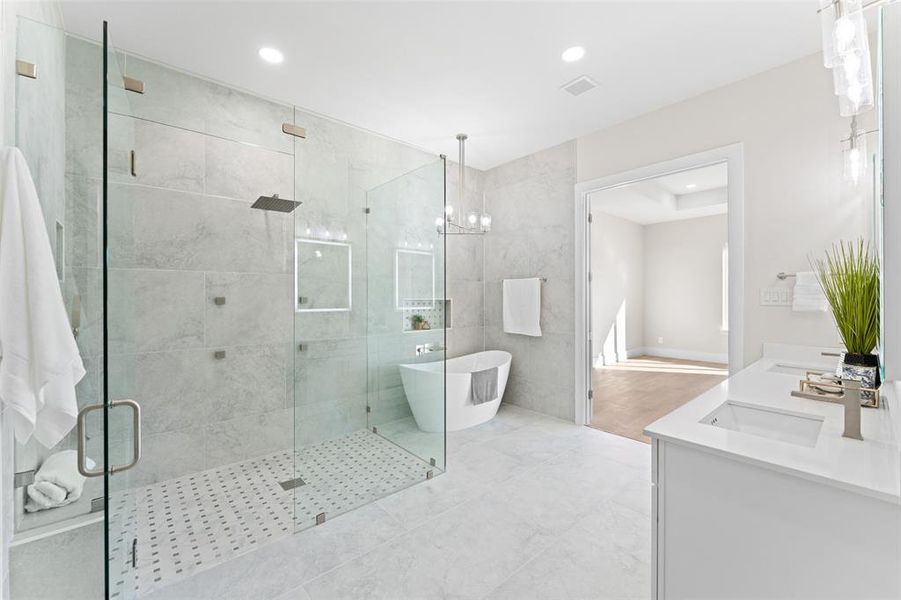 Full bathroom with a freestanding bath, a stall shower, double vanity, recessed lighting, and a chandelier Full bathroom with a freestanding bath, a stall shower, double vanity, recessed lighting, and a chandelier