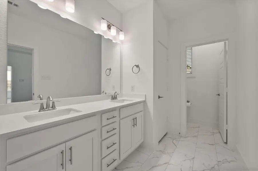 Primary Bathroom is beautiful with a double sink vanity with soft close doors, large mirror, decorative lighting, linen closet, Moen faucets, private toilet area, 42" oval freestanding bathtub, & separate shower!