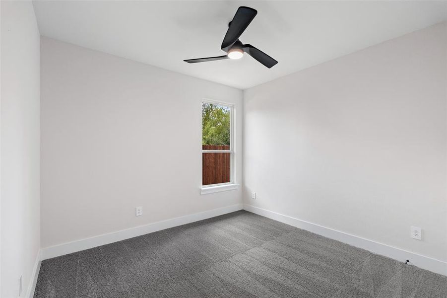 Carpeted spare room with ceiling fan