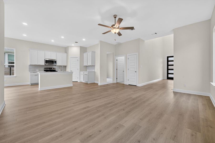 Unfurnished living room with a ceiling fan, light wood-style flooring, and recessed lighting