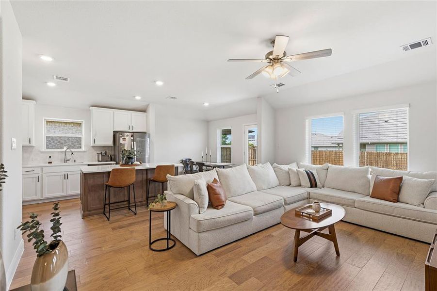 Open-concept living area featuring wood-finish flooring and recessed lighting