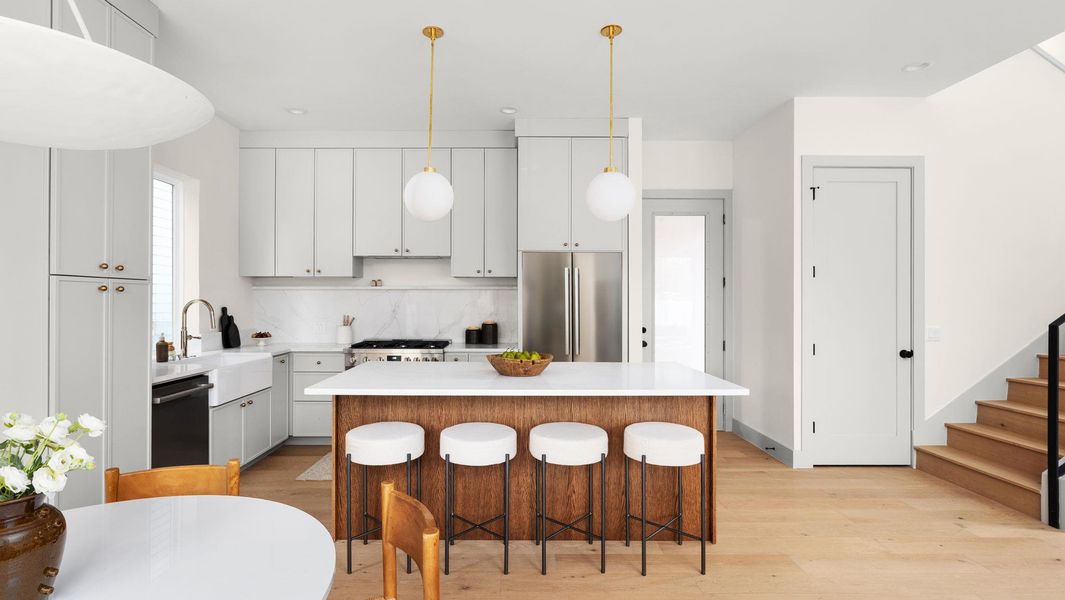 Kitchen featuring a breakfast bar area, decorative backsplash, light wood-style flooring, pendant lighting, and recessed lighting