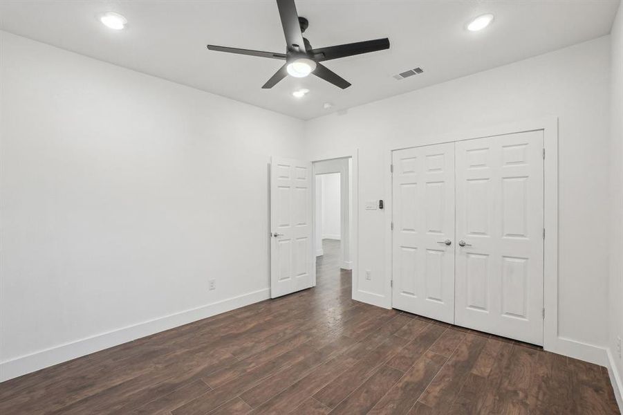 Side bedroom 3 with a closet, ceiling fan, and dark wood-type flooring