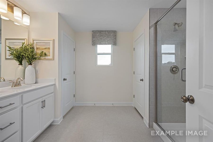 Bathroom with tile patterned flooring, vanity, and an enclosed shower