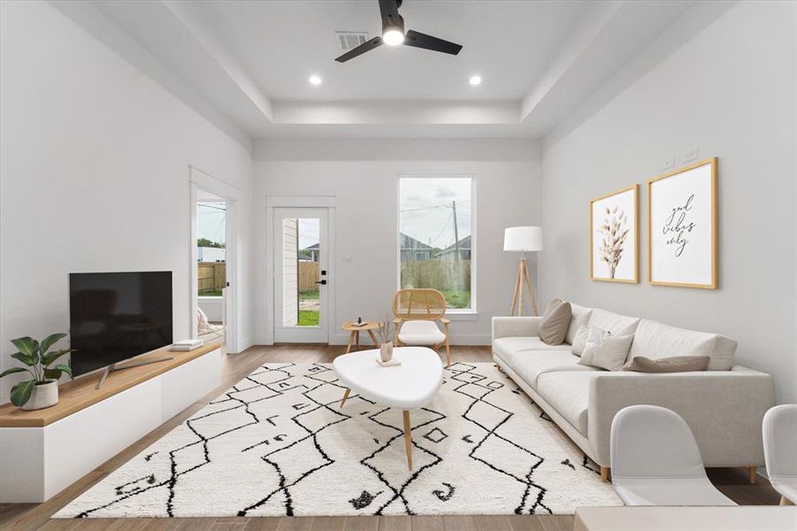 The expansive living area features access to your covered back patio and is enhanced by recessed lighting, a sleek modern fan, and a stylish tray ceiling. Take a look at that stunning picture window! (Virtually staged)