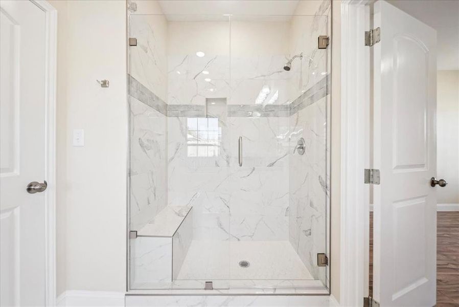 Bathroom featuring wood-type flooring and a shower with shower door