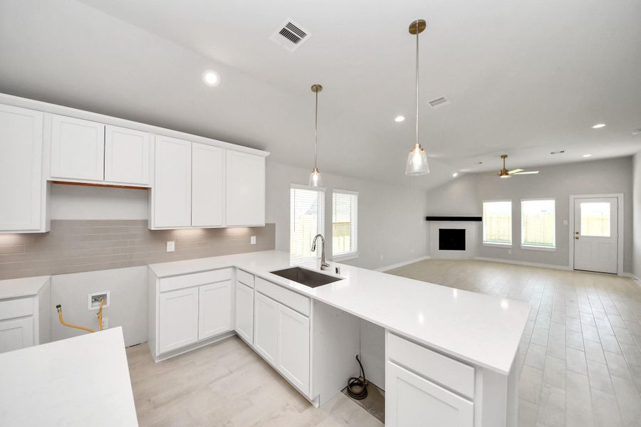 This kitchen is truly a chef's dream! This haven Boasts high ceilings, recessed & pendant lighting, stained wood cabinets, granite countertops, stainless steel appliances, a modern tile backsplash. All of this overlooks your expansive family room, creating a perfect space for culinary delights and family gatherings. Sample photo of completed home with similar floor plan. Actual colors and selections may vary. This kitchen is truly a chef's dream! This haven Boasts high ceilings, recessed & pendant lighting, stained wood cabinets, granite countertops, stainless steel appliances, a modern tile backsplash. All of this overlooks your expansive family room, creating a perfect space for culinary delights and family gatherings. Sample photo of completed home with similar floor plan. Actual colors and selections may vary.