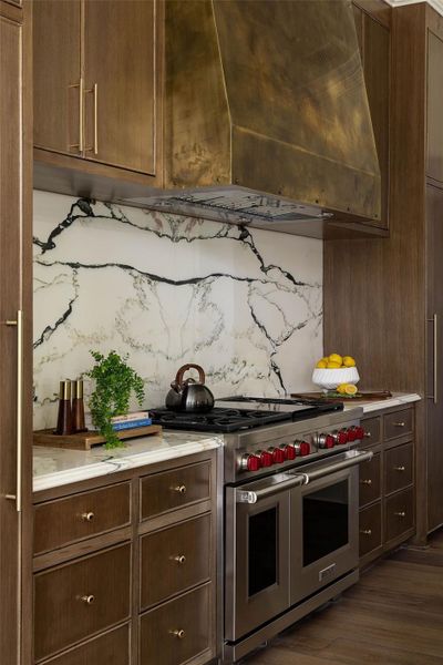 Another view of the book matched marble slabs and unlacqured brass vent hood. Additionally, the Wolf/Sub Zero appliance package makes this kitchen a chef's dream. Another view of the book matched marble slabs and unlacqured brass vent hood. Additionally, the Wolf/Sub Zero appliance package makes this kitchen a chef's dream.